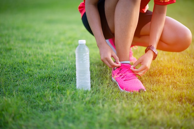 Sportler binden Schuhe, bevor sie für eine gute Gesundheit trainieren.