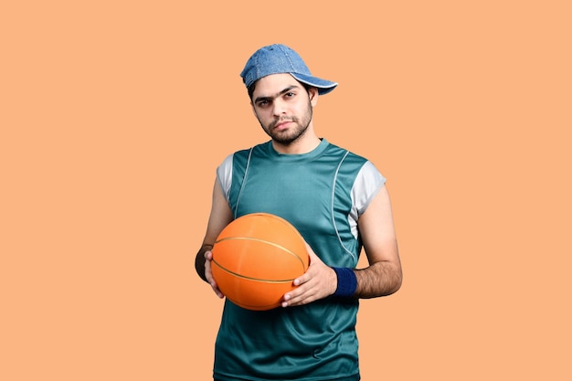 Sportler, der Basketball hält und nach vorne schaut, indisches pakistanisches Modell