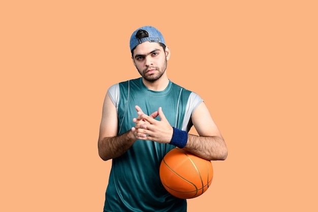 Sportler, der Basketball hält und nach vorne schaut, indisches pakistanisches Modell