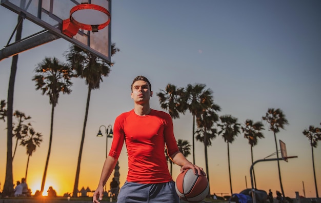 Sportler, die an einem sonnigen Sonnenaufgangstag im Freien Basketball spielen