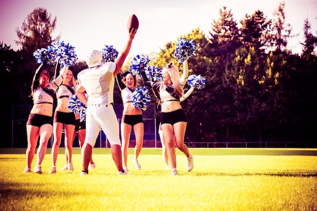 Foto sportler mit cheerleadern, die auf dem spielfeld tanzen