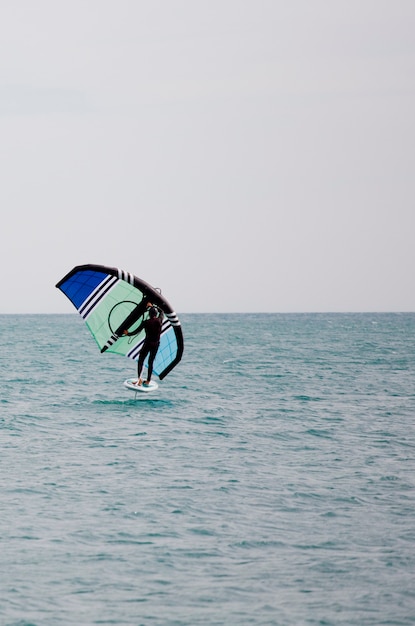 Sportler mit Wingfoil Segeln im Meer