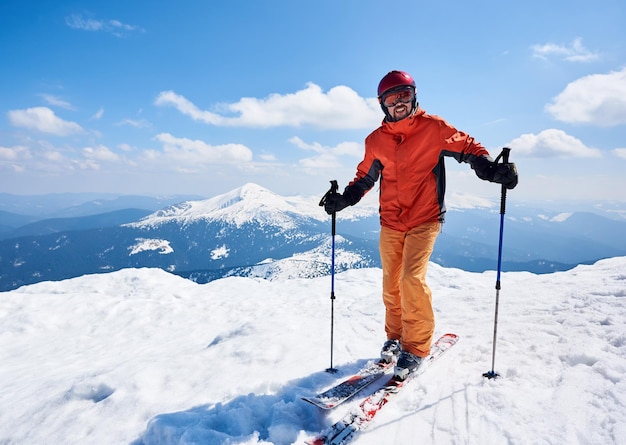 Sportler Skifahrer auf Skiern auf dem Hintergrund des blauen Himmels und der Hochlandlandschaft Winterskifahren Konzept