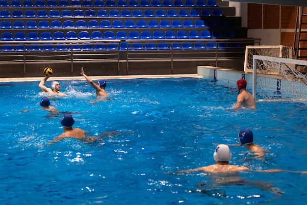 Foto sportler spielen wasserball im pool