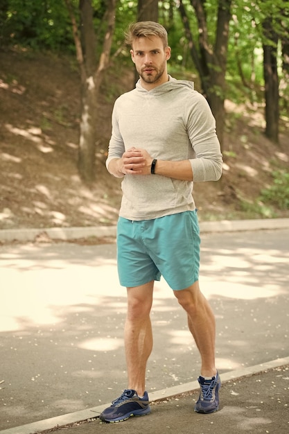 Sportler Sportlertraining im Park Muskelsportler entspannen sich nach dem Training Modesportler auf der Straße im Wald, der sich zum Laufen fertig macht
