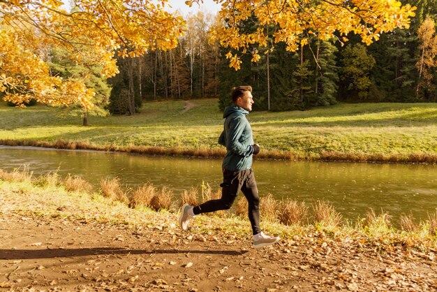 Sportler trainiert jeden Tag und im Winter Schöne helle Herbstfarben Ein Mann in warmer Sportkleidung