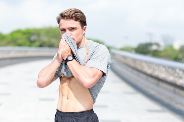 Sportler Wiping Gesicht Mit T-Shirt Im Freien