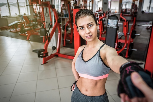 Sportlerin, die eine Kerlhand in der Turnhalle hält. Folge mir