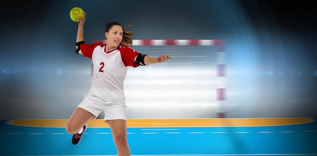 Sportlerin, die einen Ball gegen das Handballfeld wirft