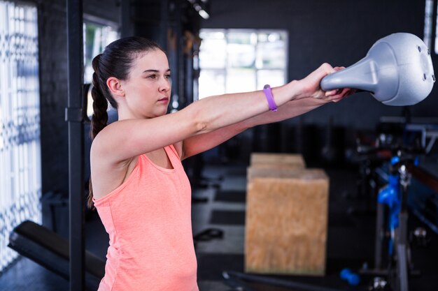 Sportlerin, die Kettlebell im Fitnessstudio hält