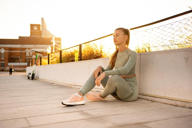 Sportlerin, die nach dem morgendlichen Training im Sommerpark sitzt