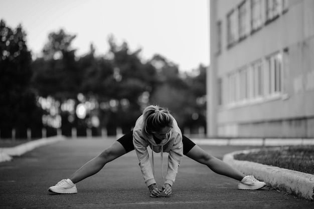 Sportlerin, die Sport treibtSportliche junge Frau, die morgendliche Übungen macht, Schwarz-Weiß-Foto