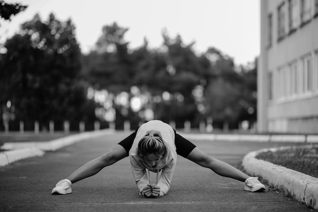 Sportlerin, die Sport treibtSportliche junge Frau, die morgendliche Übungen macht, Schwarz-Weiß-Foto