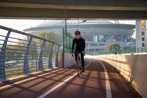 Sportlerin fährt bei Sonnenaufgang über die Brücke