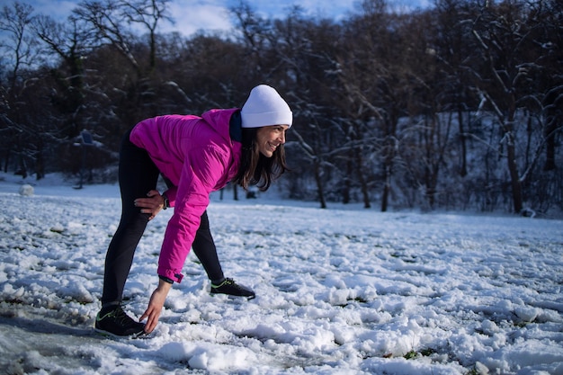 Sportlerin im Winterkleidungstraining auf Schnee.