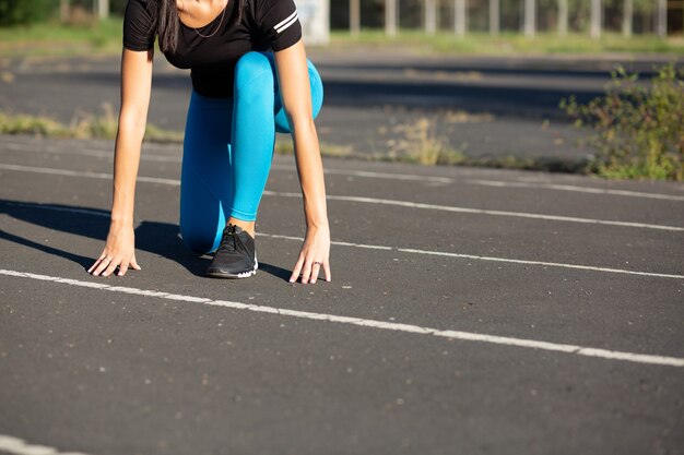 Sportlerin in Ausgangsposition bereit für den Lauf. Freiraum