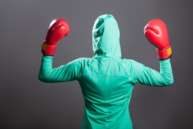 Sportlerin in grüner Sportkleidung auf grauem Hintergrund