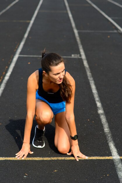 Sportlerin läuft auf sportlicher Strecke und trainiert ihr Cardio.