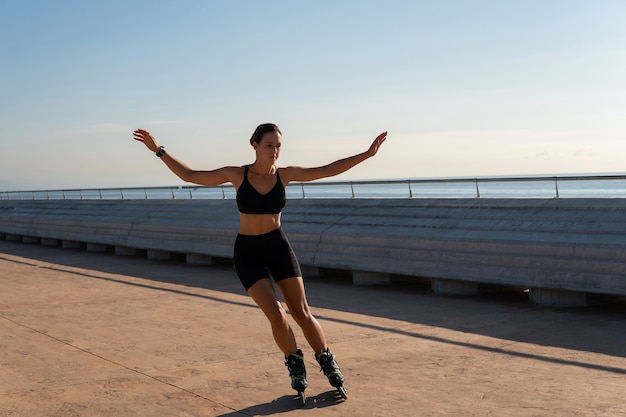 Sportlerin reitet Rollerblades auf Böschung