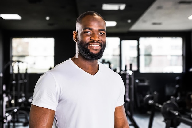 Sportlich lächelnder afrikanischer Mann, der sich nach dem Training ausruht und Pause macht