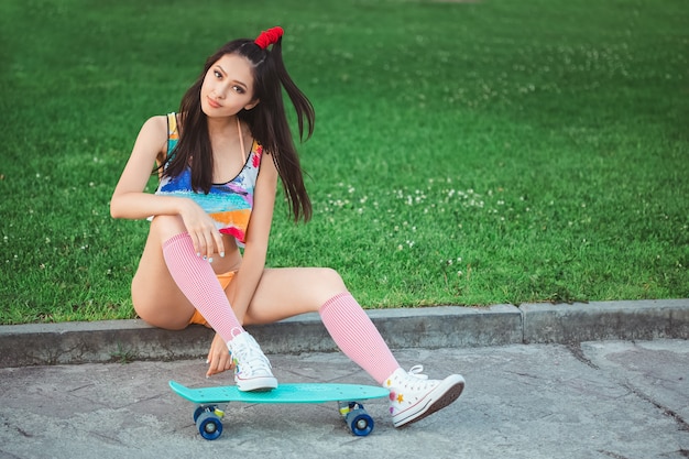 Sportliche asiatische Frau mit Skateboard