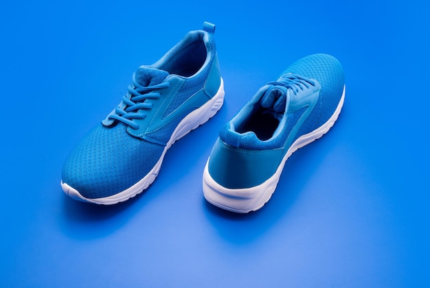 Sportliche blaue Turnschuhe auf blauem Hintergrund Schuhgeschäft Einkaufskonzept Schuhe für das Training von Sportschuhen zum Laufen von Paar bequemen Sportschuhen