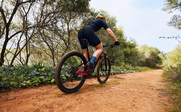 Sportliche Fitness und Radfahren mit einer Frau auf unbefestigten Wegen in der Natur für Training und Wettkampf. Starkes Cardio-Training und Training mit einer Radfahrerin auf dem Mountainbike für Abenteuer und Reisen