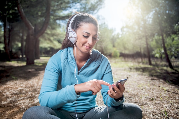 Sportliche Frau, bevor sie mit dem Einrichten ihrer Smartphone-App beginnt, Fitnesskonzept