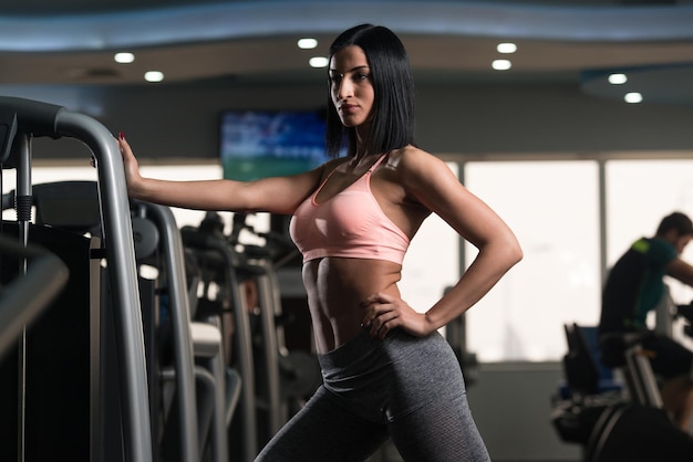 Sportliche Frau dehnt sich im Fitnessstudio aus
