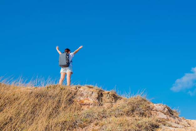 Sportliche Frau, die auf die Klippe klettert. Erfolgs- und Zielkonzept. Starke Frauenpower und gesund für sportliche Aktivitäten im Freien.