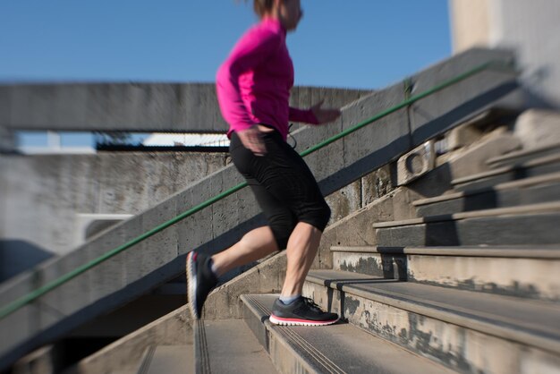 sportliche Frau, die beim Joggen am frühen Morgen auf Schritte läuft