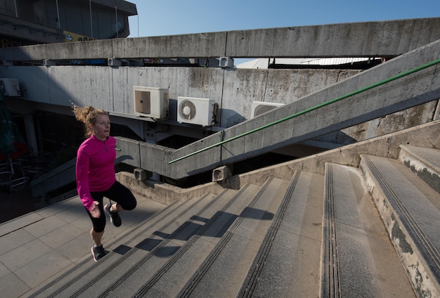 sportliche Frau, die beim Joggen am frühen Morgen auf Schritte läuft