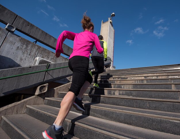 Foto sportliche frau, die beim joggen am frühen morgen auf schritte läuft