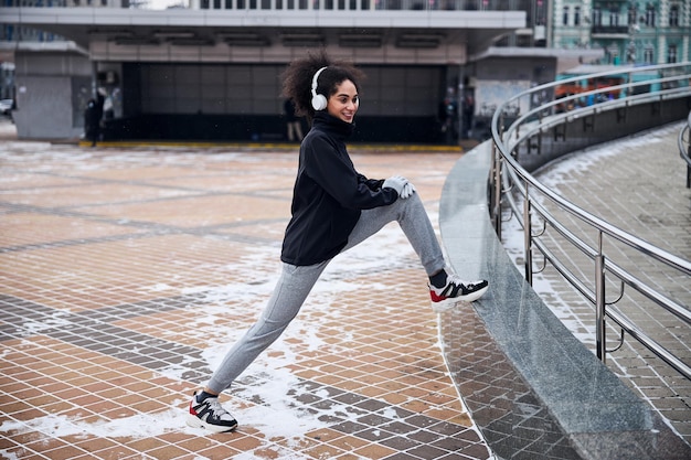 Sportliche Frau, die ihr Bein auf einen Bordstein legt