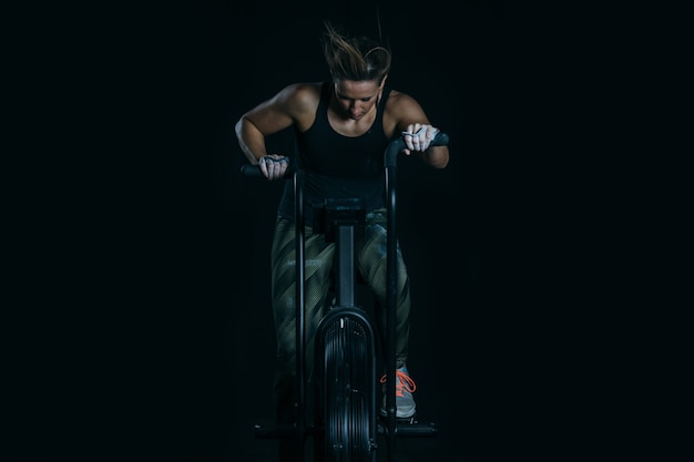 Foto sportliche frau, die kalorien-angriffsfahrrad tut