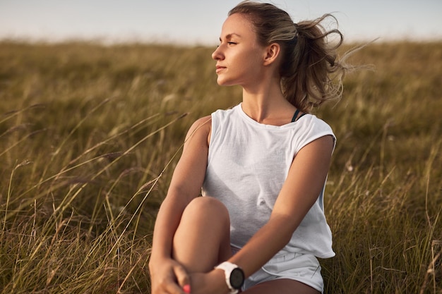 Sportliche Frau ruht im Feld