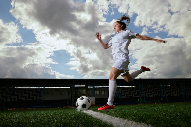 Sportliche Fußballspielerin mit einem Fußball auf dem Fußballplatz das Konzept des professionellen Frauenfußballs