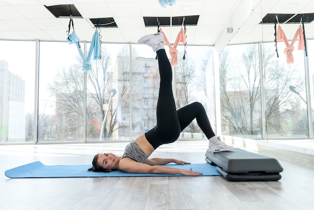 Sportliche junge Frau, die nach dem Arbeitstag im Fitnessstudio trainiert. Gesunder Lebensstil