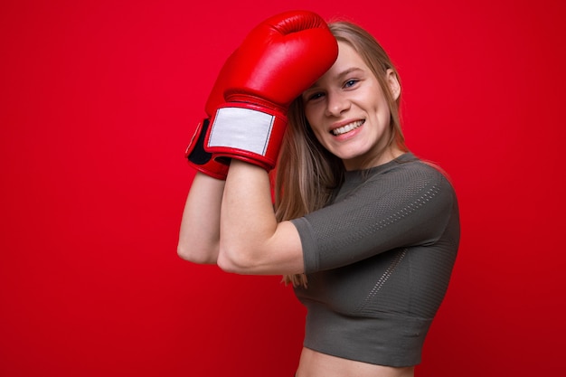 Sportliche junge Frau in roten Boxhandschuhen im Training