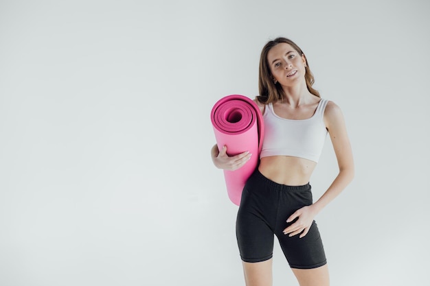 Sportliche junge Frau macht Yoga-Praxis isoliert auf weißem Hintergrund. Konzept des gesunden Lebens