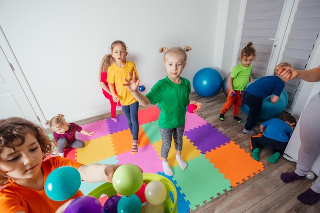 Sportliche Kinder, die Aktivitäten mit jungem Lehrer genießen