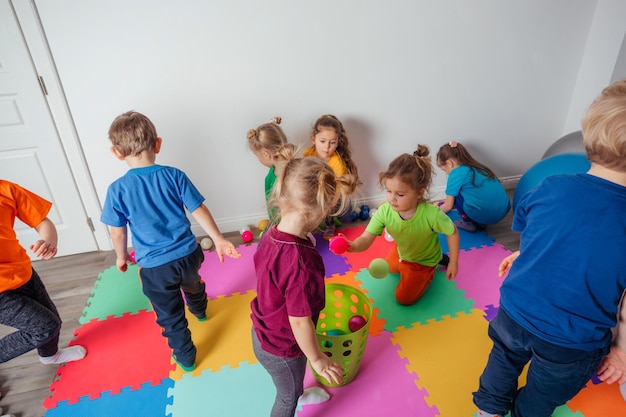 Sportliche Kinder, die Aktivitäten mit jungem Lehrer genießen