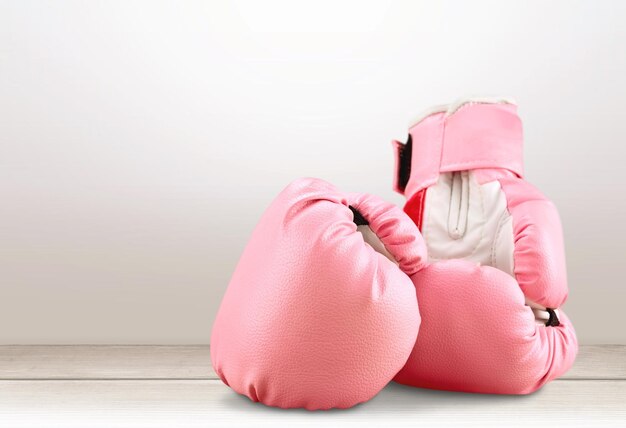 Sportliche rosa Boxhandschuhe auf pastellfarbenem Hintergrund