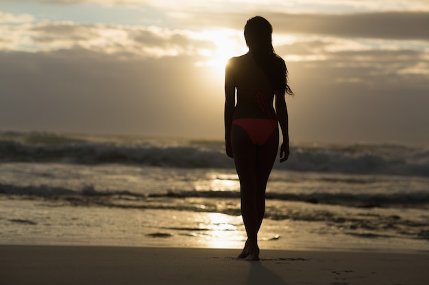 Sportlicher Brunette, der auf den Strand geht