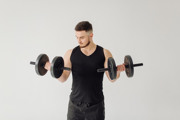 Sportlicher junger Mann, der zu Hause trainiert, Mann, der trainiert, sich vor dem Krafttraining aufwärmt.