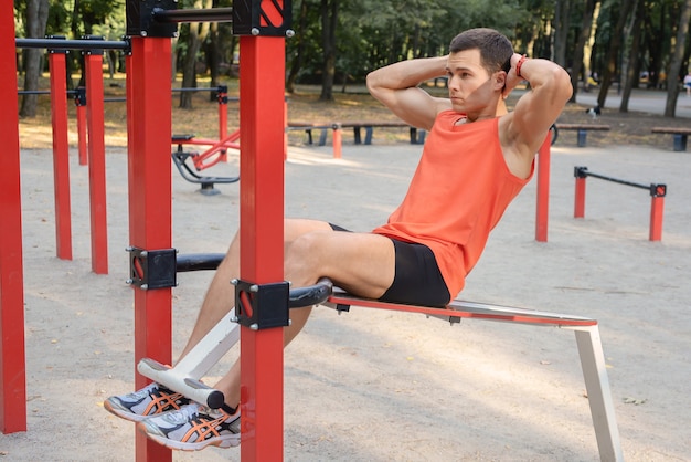 Sportlicher junger Mann macht Liegestütze im Freien Fitness und Outdoor-Training in einer städtischen Umgebung