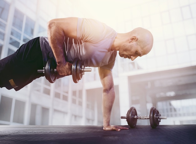 Sportlicher Mann, der Muskeln im Fitnessstudio trainiert