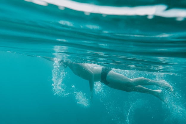 Sportlicher Mann schwimmt schnell im Meer