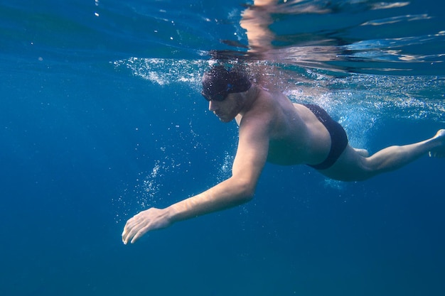 Sportlicher Mann schwimmt schnell im Meer