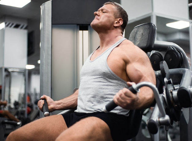 Sportlicher Mann trainiert im Fitnessstudio.